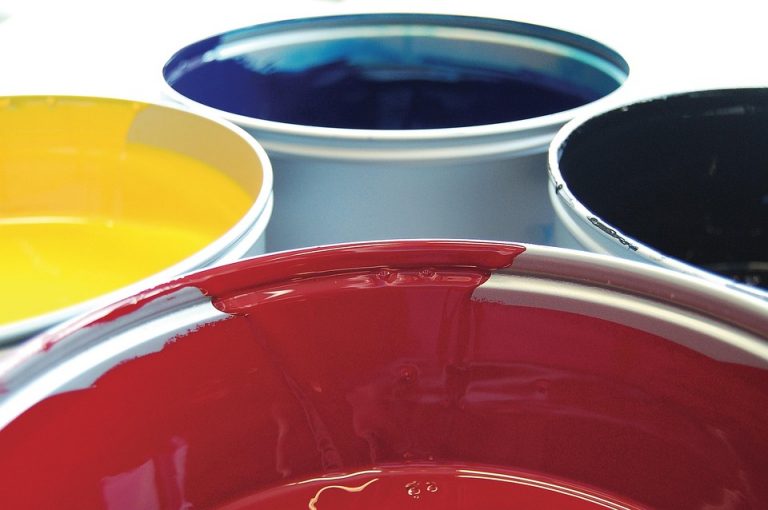 Cans of colorful ink in yellow, red, blue, and black.