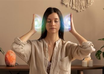 Calm woman meditating with hands aura.