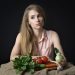 Young woman with fresh vegetables on a table.