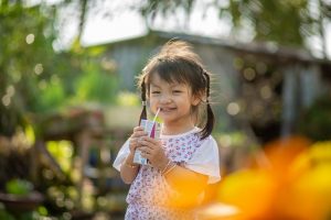 Girl enjoying a juice box outdoors