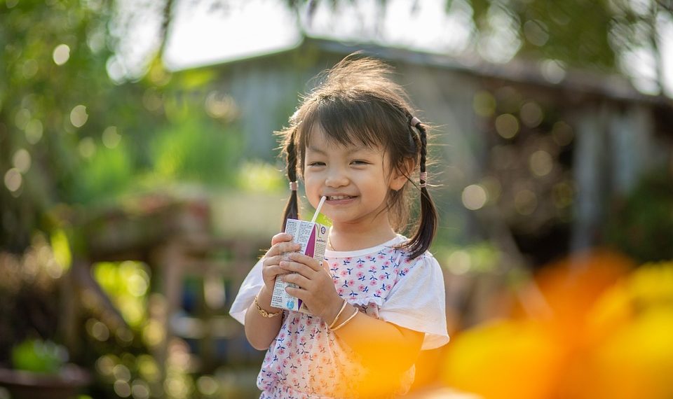 Girl enjoying a juice box outdoors