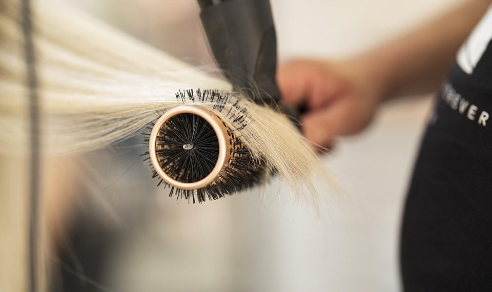 Hair styling with round brush and blow dryer.