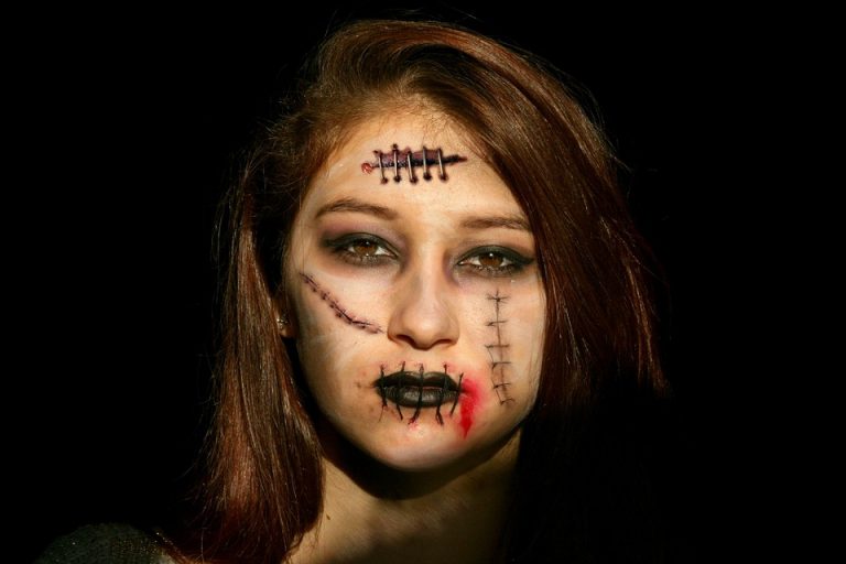 Young woman with horror makeup and stitches on face.