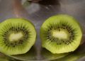 Sliced fresh kiwi revealing seeds and green flesh.