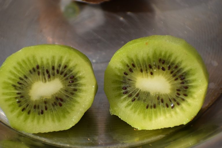 Sliced fresh kiwi revealing seeds and green flesh.