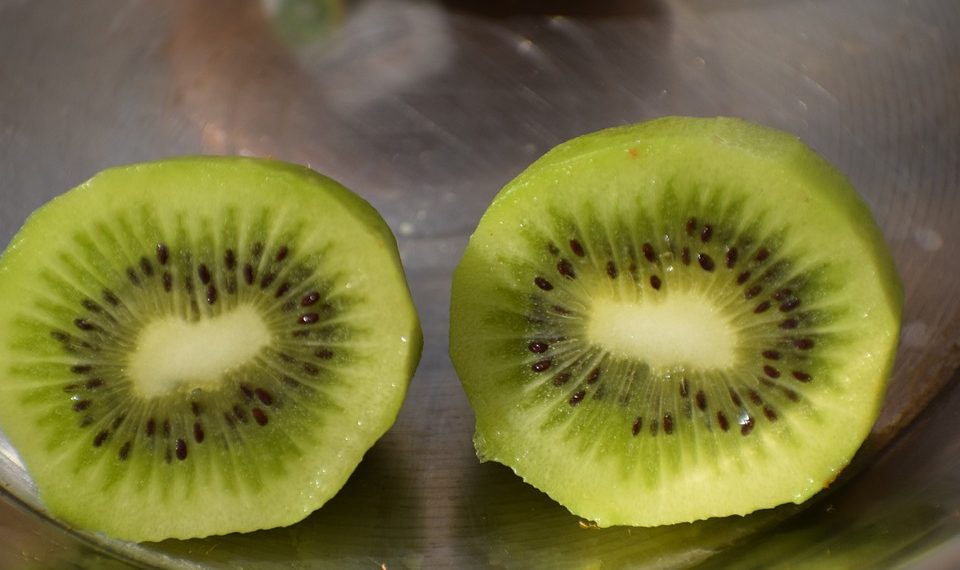 Sliced fresh kiwi revealing seeds and green flesh.