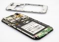 Disassembled smartphone showing internal components and circuit board.