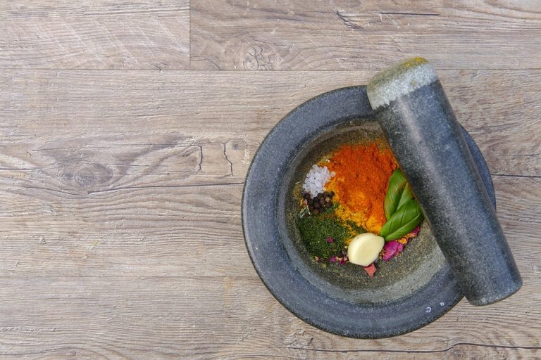Mortar and pestle with colorful spices and herbs.