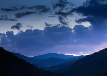 Mountain landscape at twilight with dramatic clouds.
