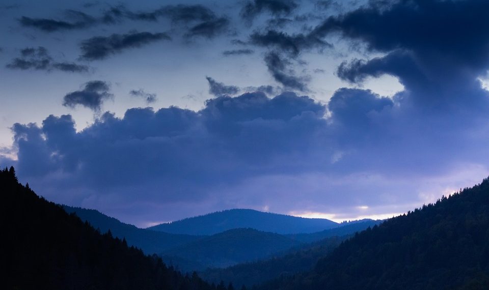 Mountain landscape at twilight with dramatic clouds.