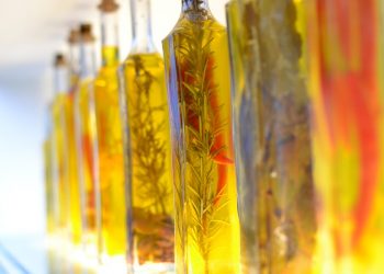 Bottles of infused olive oil with herbs and spices.