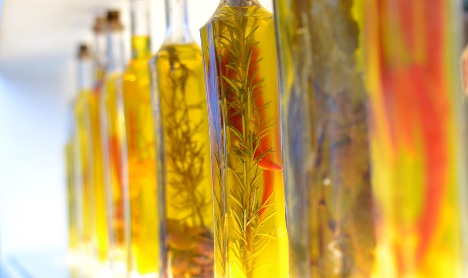 Bottles of infused olive oil with herbs and spices.