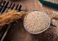 Bowl of quinoa grains on a wooden table.