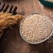 Bowl of quinoa grains on a wooden table.