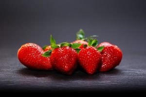 Fresh ripe strawberries on dark background.