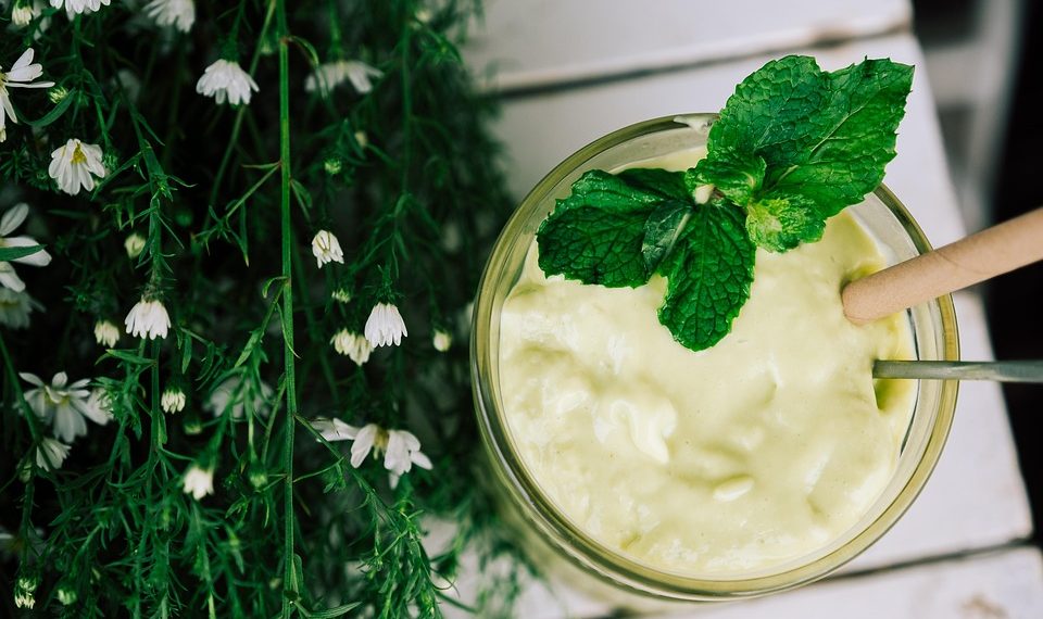 Creamy avocado smoothie garnished with fresh mint leaves.