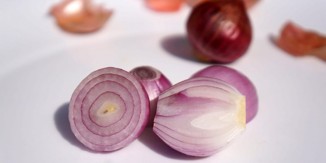 Sliced red onions on a white surface.
