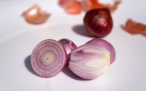 Sliced red onions on a white surface.