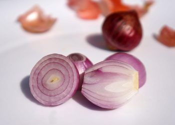 Sliced red onions on a white surface.
