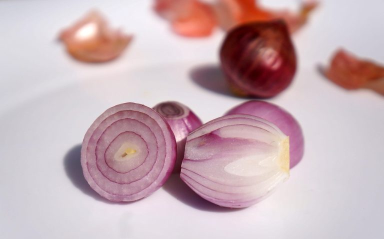 Sliced red onions on a white surface.
