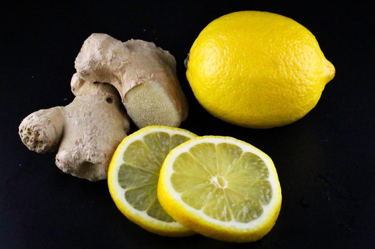 Ginger and fresh lemon slices on black background.