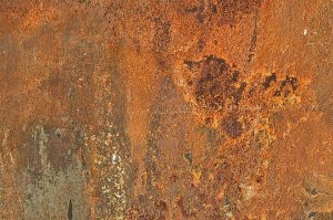 Rusty metal surface texture with orange and brown tones.