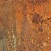 Rusty metal surface texture with orange and brown tones.