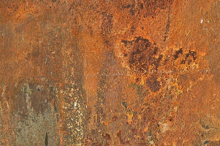 Rusty metal surface texture with orange and brown tones.