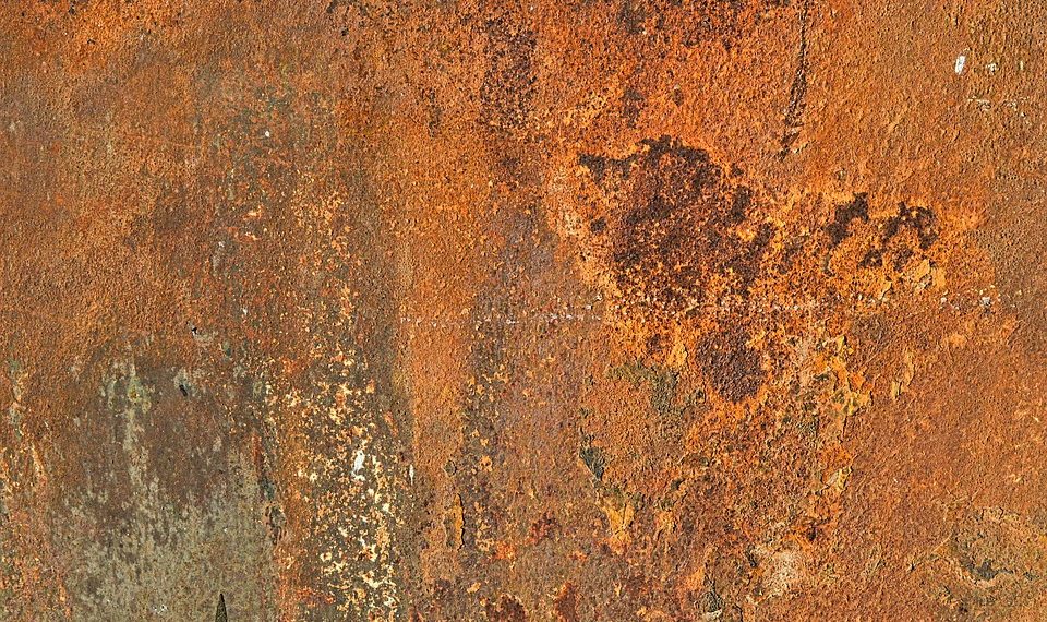Rusty metal surface texture with orange and brown tones.