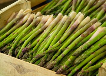 Fresh asparagus spears stacked in a crate.