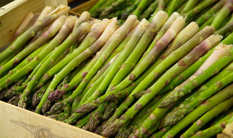 Fresh asparagus spears stacked in a crate.