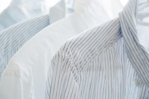White and blue striped shirts on hangers.