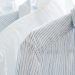 White and blue striped shirts on hangers.