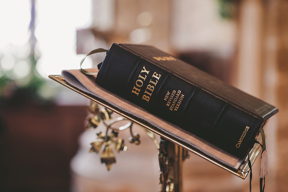 Holy Bible on a lectern in church setting.