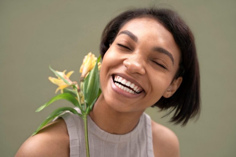 Close up smiley woman posing with flower