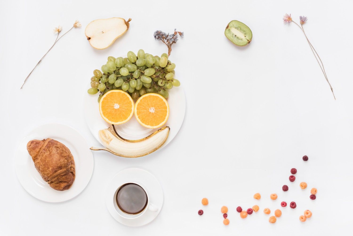 Food arranged as human face on plate with coffee; croissant and coffee