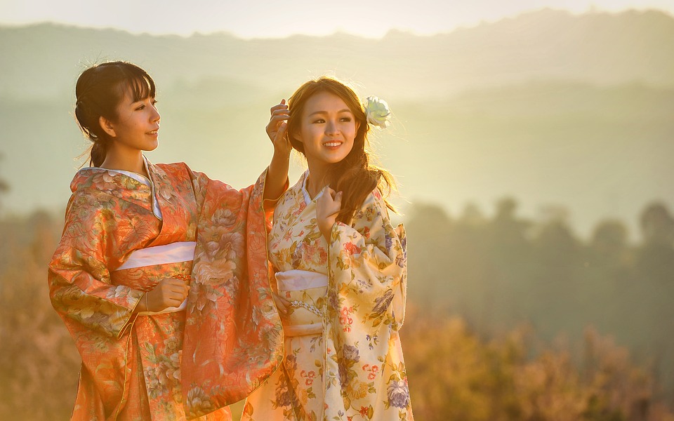 Two women in traditional kimonos enjoying a scenic sunset.