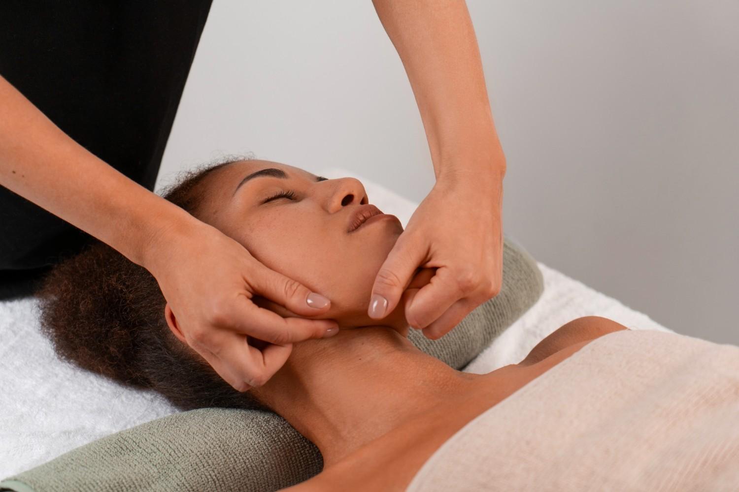 View of woman getting a facial yoga jaw massage to stay young