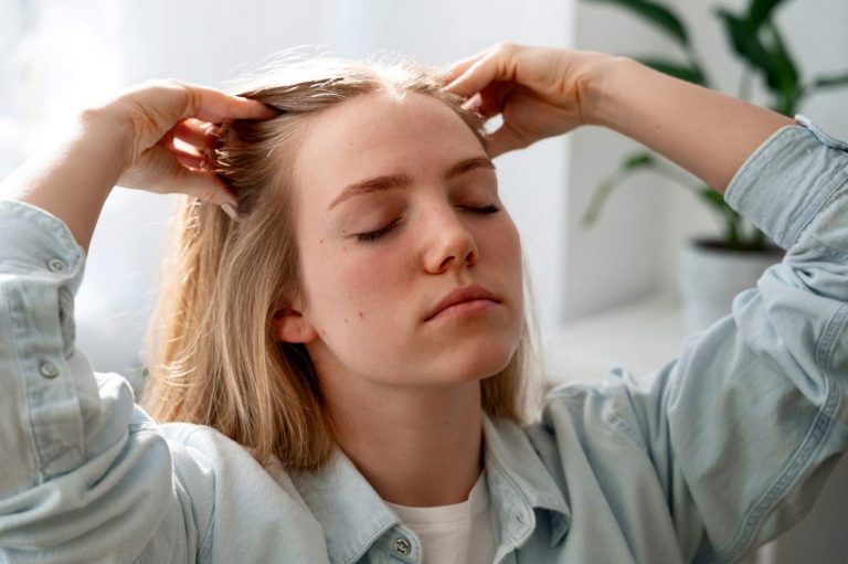 Woman giving herself scalp massage