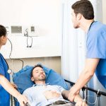 Team of doctors examining blood pressure of a patient and looking at heart