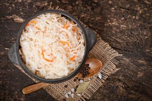 Sauerkraut with carrot in wooden bowl