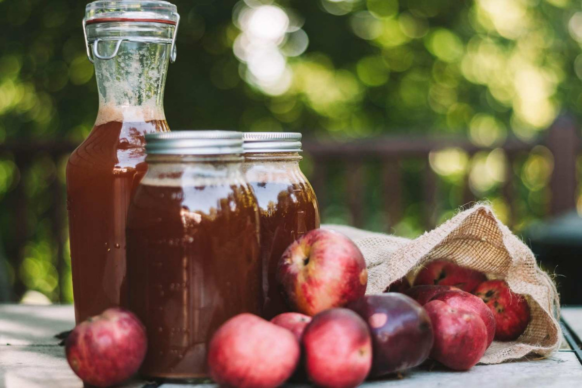 apple cider vinegar jar and glass on a table