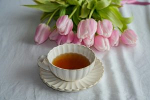A cup of tea with pink tulips