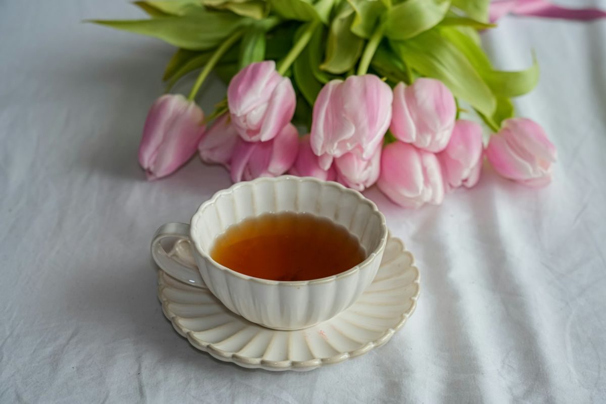 A cup of tea with pink tulips