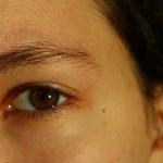 A close up of a woman's face with a brown eye