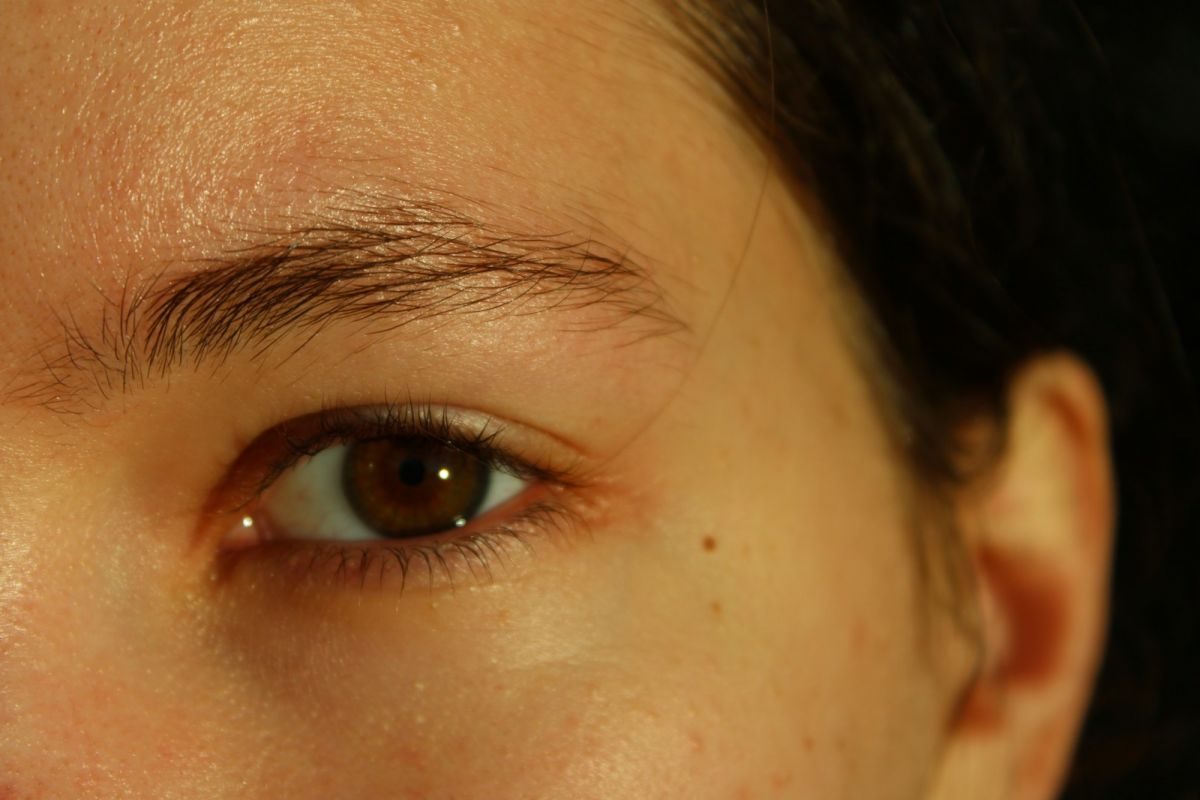 A close up of a woman's face with a brown eye