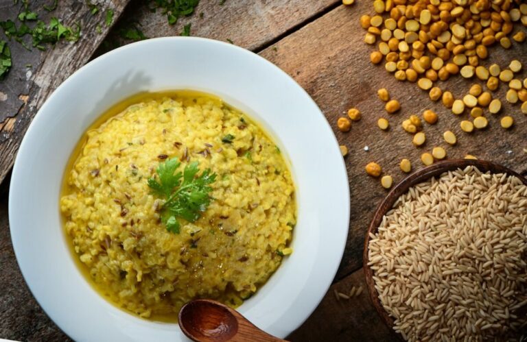 white ceramic bowl with yellow soup and moringa