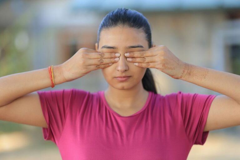 Young woman covering her eyes with hands