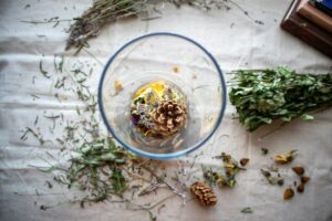 A glass bowl filled with a mixture of dried herbs