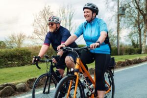 a man and a woman riding bikes on a road